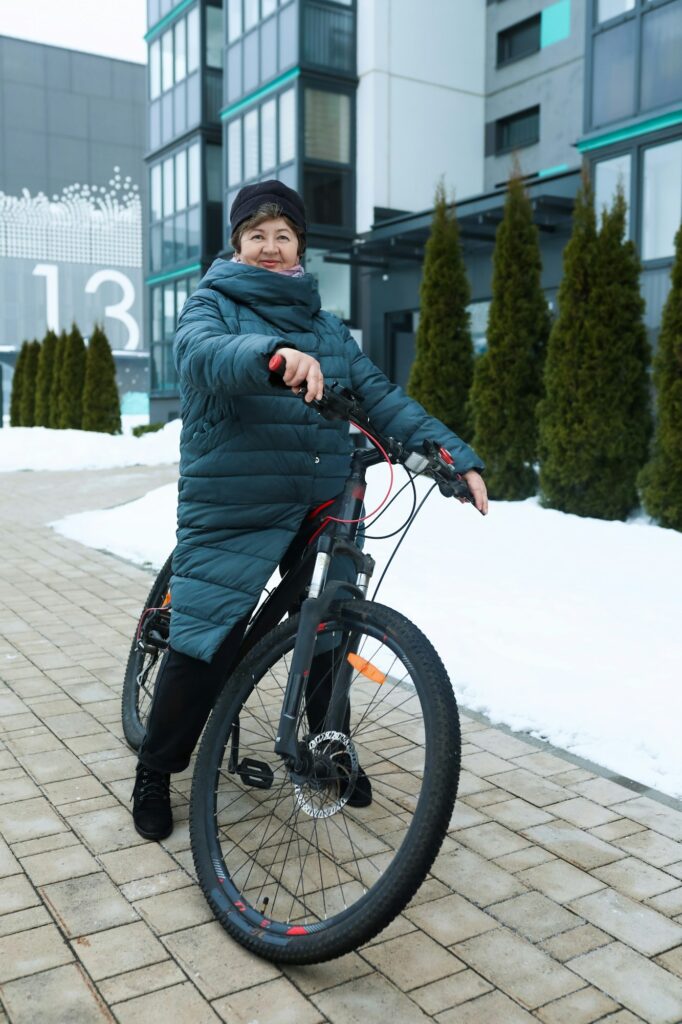 Elderly woman doing sports and riding a bicycle on the street